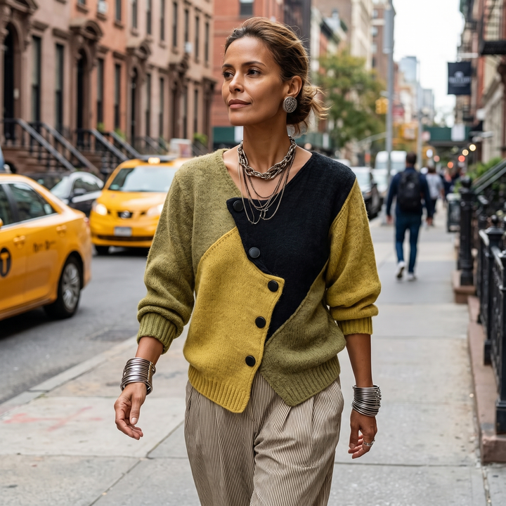 Femme marchant dans une rue de New York, vêtue du pull colorblock à boutons asymétriques et d'un pantalon rayé. 4