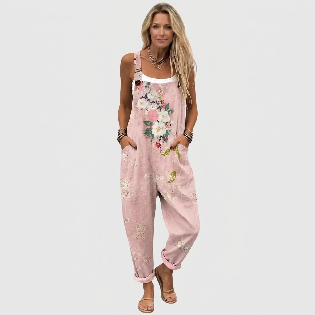 Femme blonde en pied, de face, portant la salopette rose à fleurs sur un débardeur blanc, avec des sandales. 2