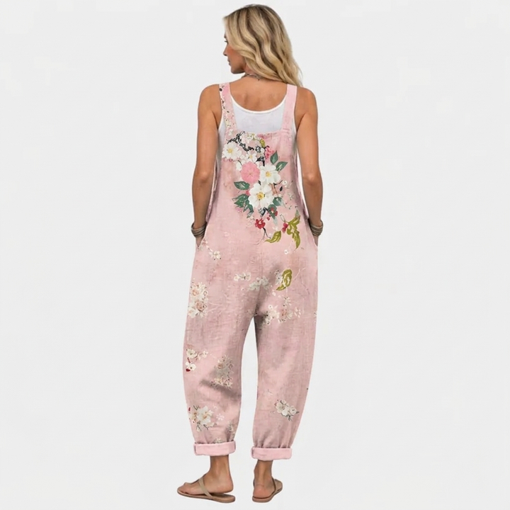 Femme de dos portant la salopette rose, avec le bouquet de fleurs imprimé dans le dos et les bas de jambes retroussés. 4