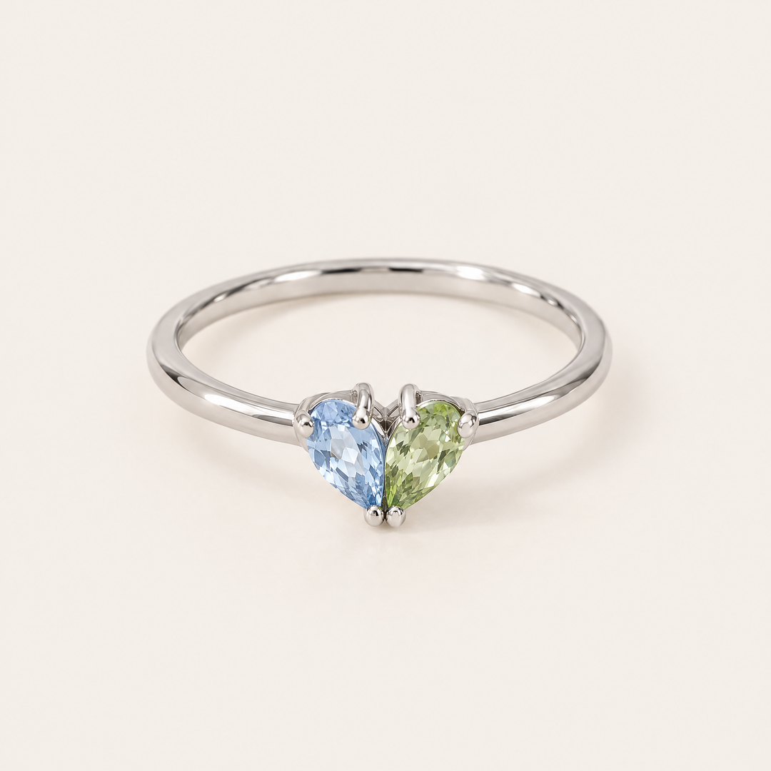 Bague argentée de face avec une pierre bleu clair et une pierre vert pomme en forme de goutte, réunies en cœur. 5