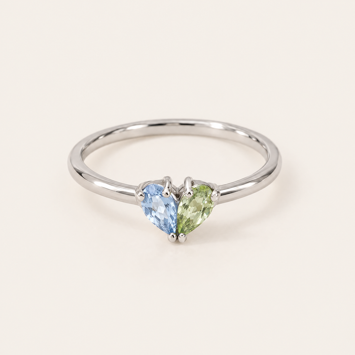 Bague argentée de face avec une pierre bleu clair et une pierre vert pomme en forme de goutte, réunies en cœur. 5