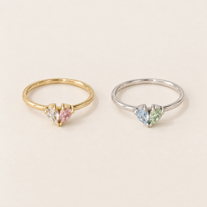 Deux bagues côte à côte : l'une dorée avec pierres transparente et rose, l'autre argentée avec pierres bleu clair et verte. 4
