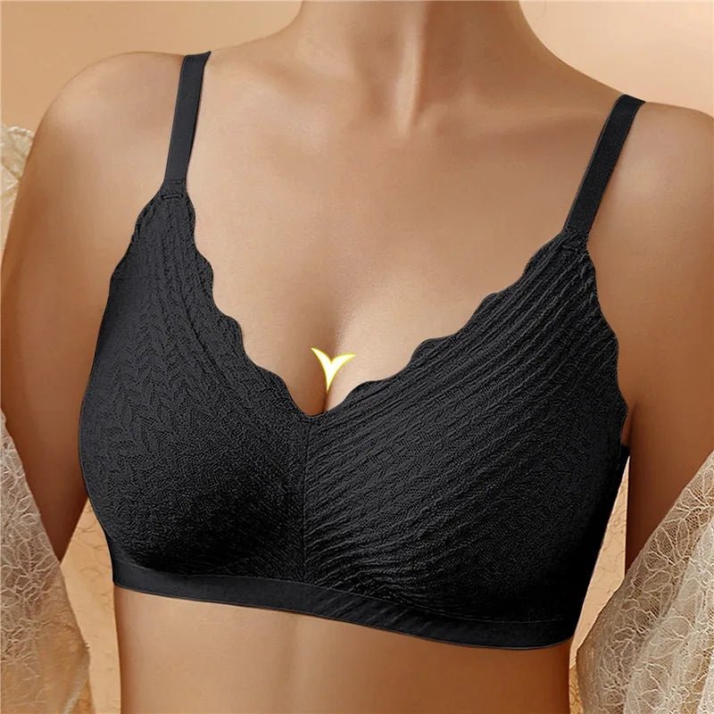 Brassière noire sans armatures portée de face, avec bonnets texturés et bordure festonnée au décolleté en V. 1