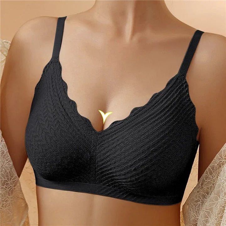 Brassière noire sans armatures portée de face, avec bonnets texturés et bordure festonnée au décolleté en V. 1