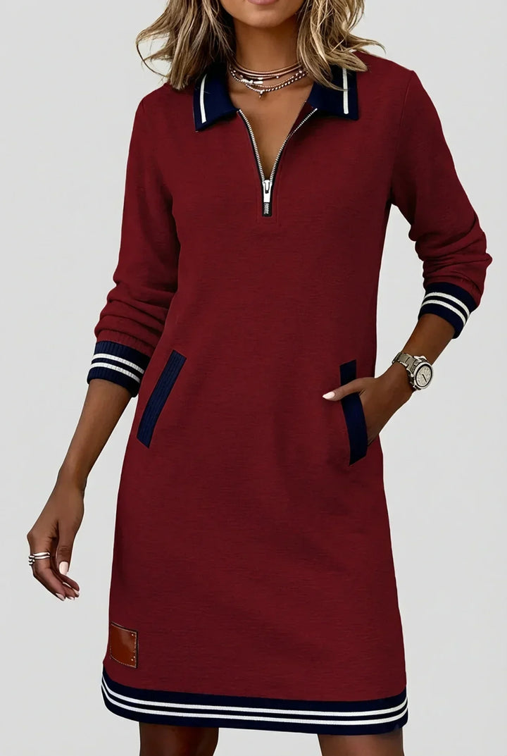 Robe bordeaux à col polo bleu marine, portée par un mannequin la main dans la poche, ourlet rayé. 5