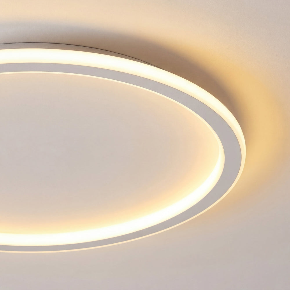 Gros plan sur le détail de l'anneau lumineux et du cadre blanc du plafonnier, avec halo de lumière chaude. 2