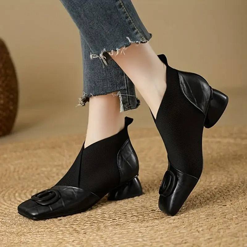 Paire de bottines noires en cuir et maille portées avec un jean effiloché, vue de côté et de face 2