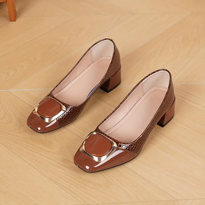 Paire d'escarpins marron posée sur un parquet, vue du dessus montrant l'intérieur doublé de beige clair et la boucle dorée. 4