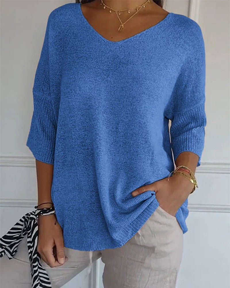 Pull bleu en maille fine à col V porté par une femme, avec pantalon beige 1