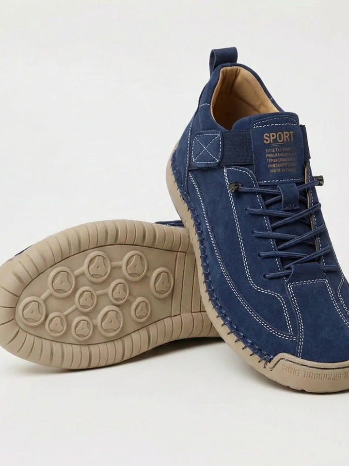Version bleu marine en suédine, une chaussure appuyée sur l'autre dévoilant la semelle beige à plots 2