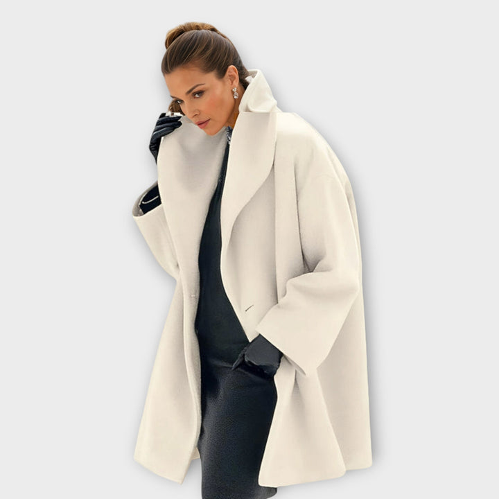 Femme en manteau blanc crème à col relevé, chignon haut, gants noirs et robe noire en dessous. 6