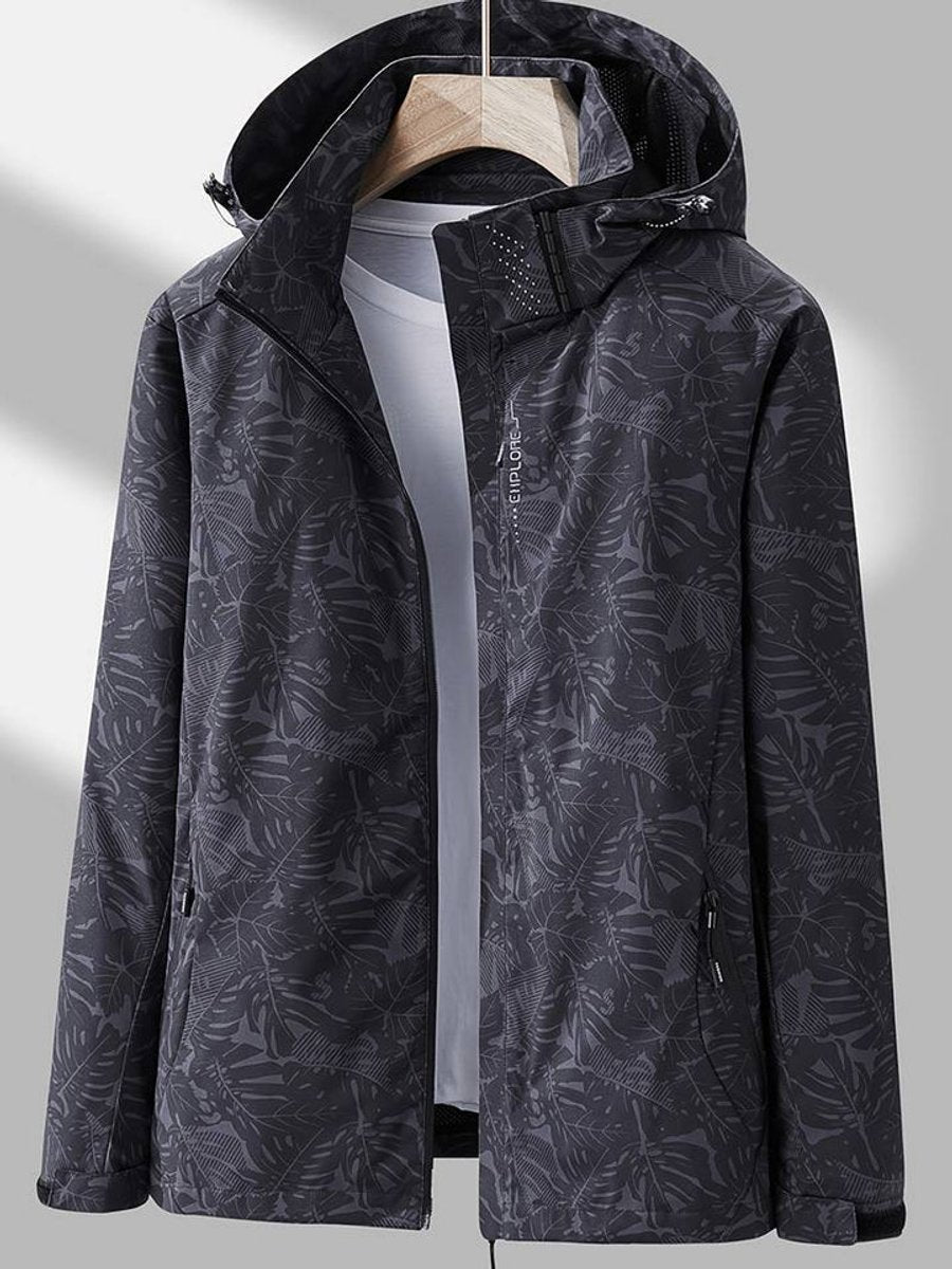 Veste gris anthracite foncé à motif de feuilles, capuche relevée, zip ouvert sur un t-shirt gris clair, vue de face. 6