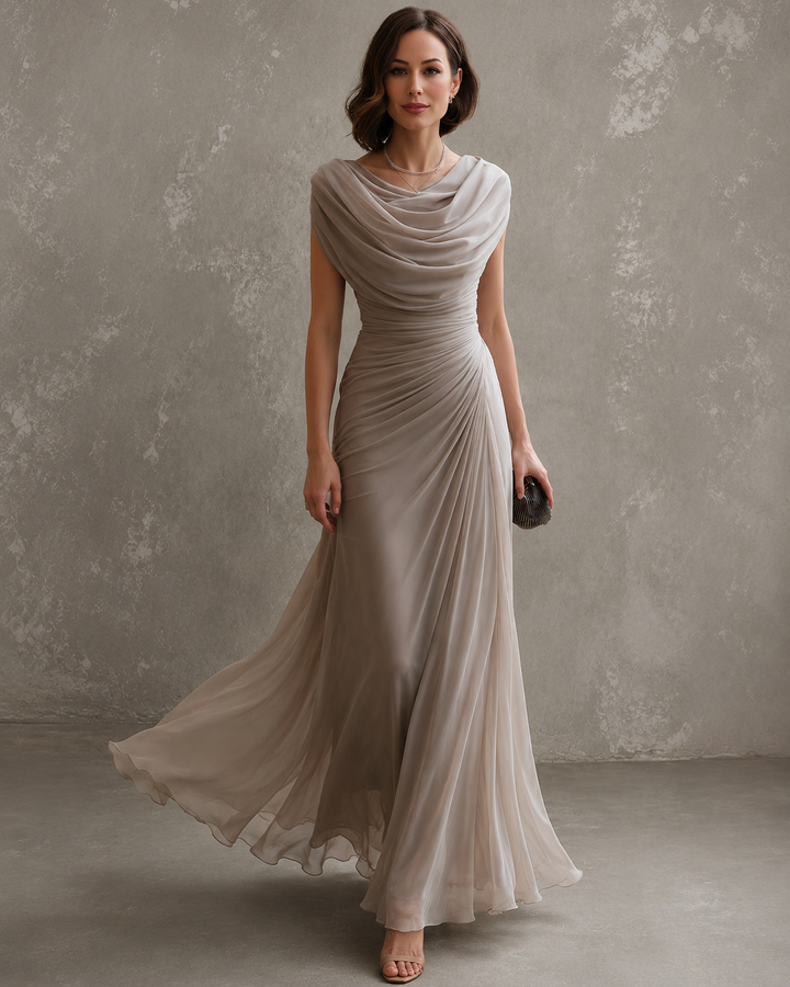 Femme portant la robe longue taupe à col bénitier drapé, jupe fluide en mouvement, vue de face en pied avec pochette. 1