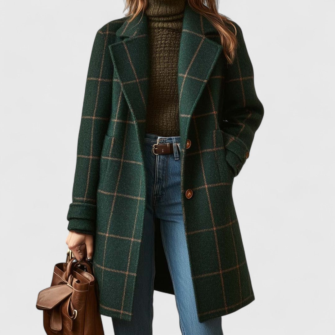 Femme de face portant le manteau vert à carreaux ouvert sur un col roulé, un jean et un sac en cuir marron. 1