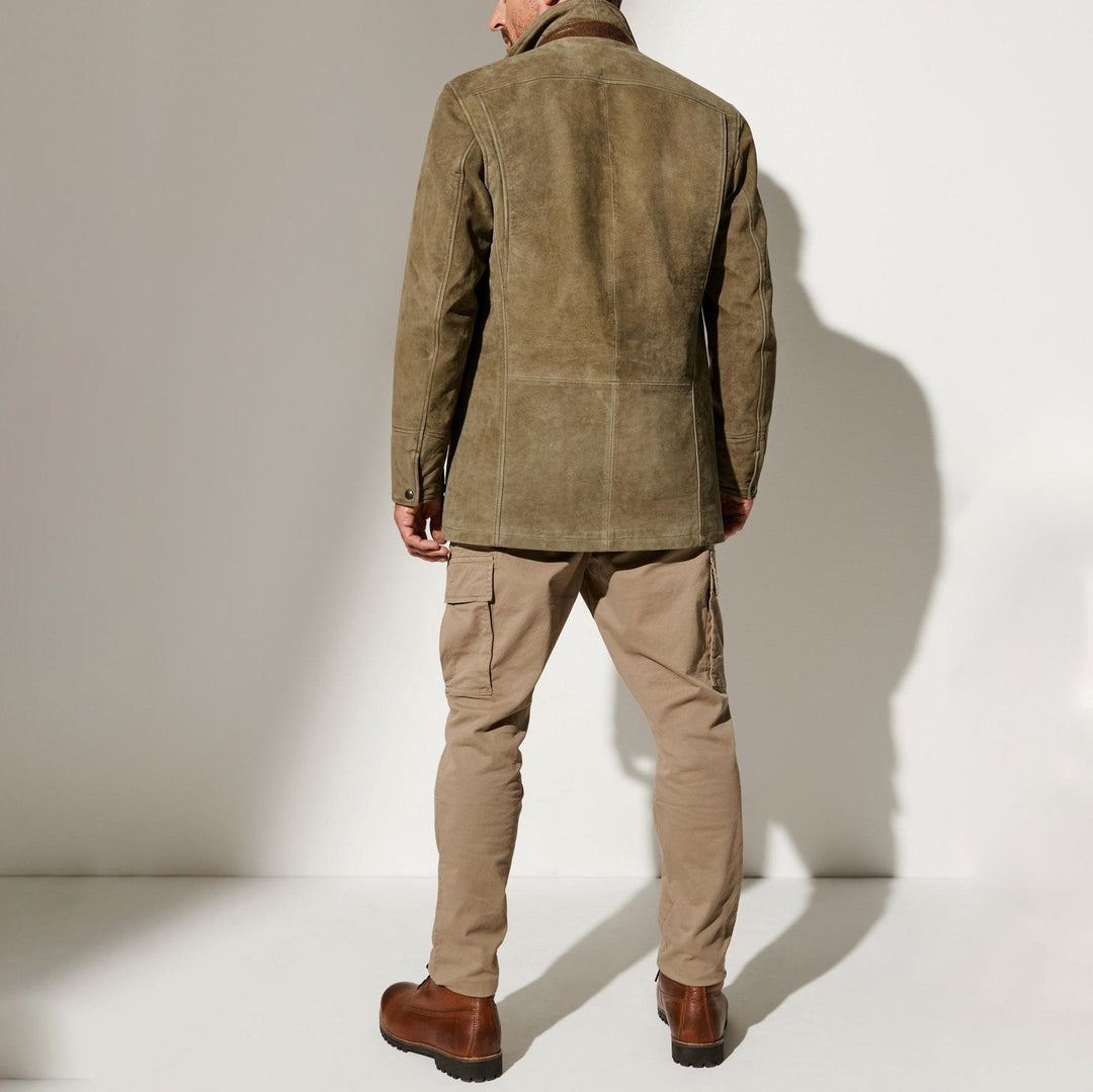Homme vu de dos portant la veste en daim kaki, avec pantalon cargo beige et bottines en cuir brun. 3