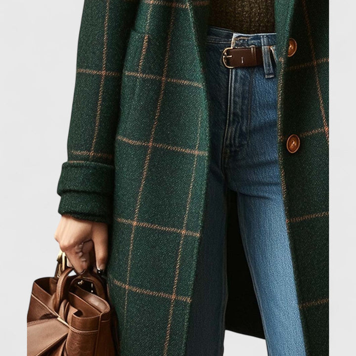 Détail du bas du manteau côté gauche, avec manche retroussée, poche plaquée et main tenant un sac en cuir marron. 4