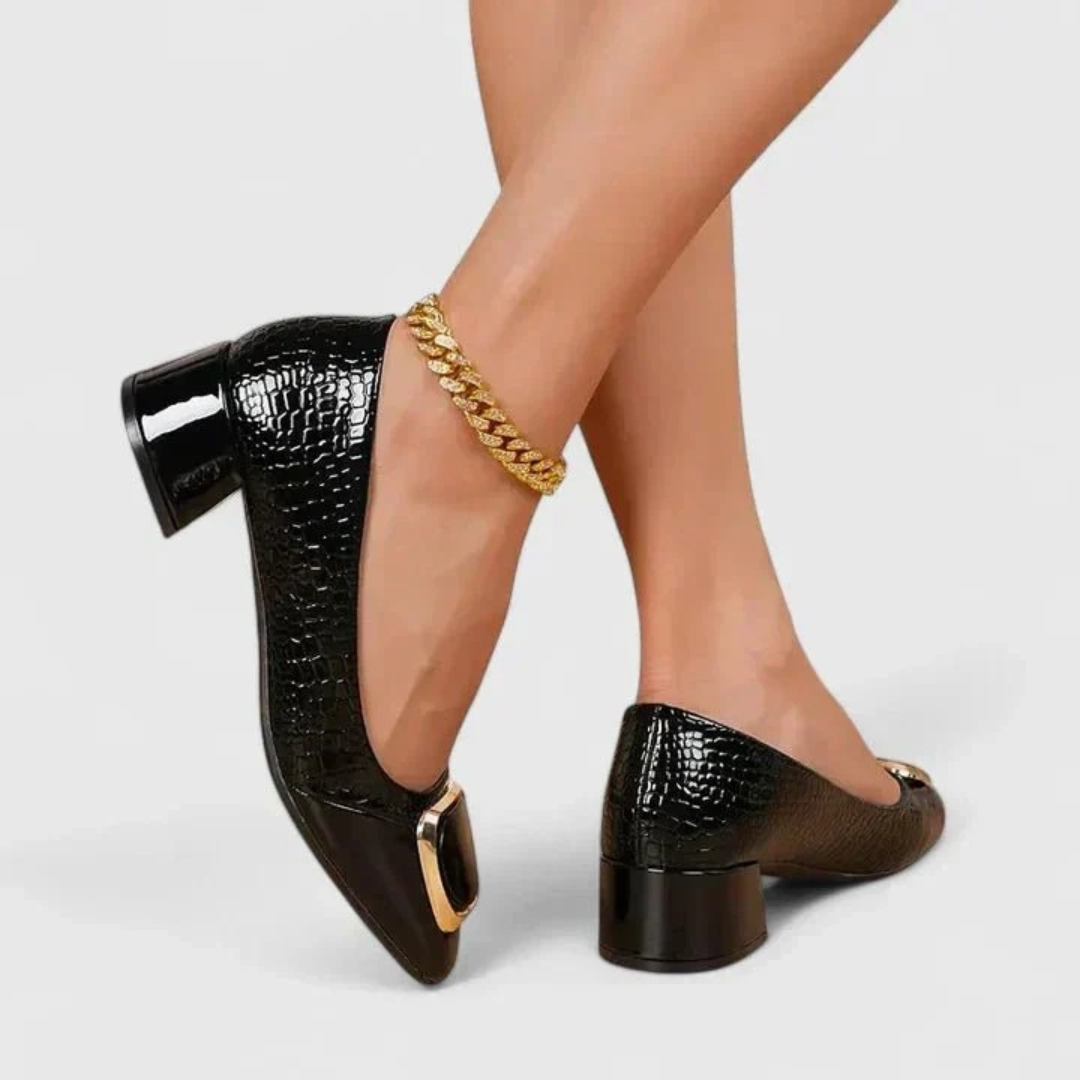 Mocassins noirs vernis à effet croco portés, jambes croisées, avec ornement doré et chaîne dorée à la cheville. 7