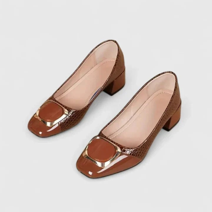 Paire de mocassins marron à talon carré et bout carré, vue du dessus, avec ornement métallique doré sur le devant. 1