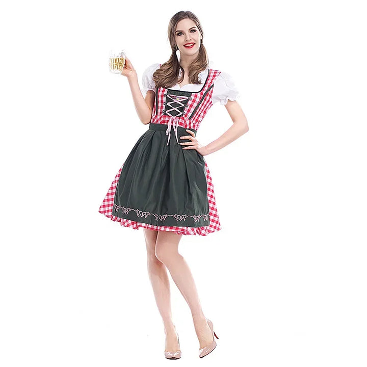 Femme en dirndl à carreaux rouges et blancs avec tablier vert foncé brodé, tenant une chope de bière, vue de face. 1