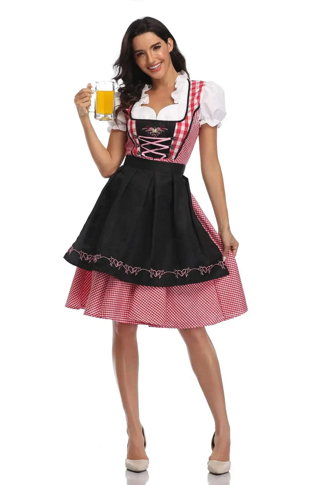 Dirndl à carreaux rouges avec tablier noir brodé de cœurs roses, porté de face par un modèle tenant une chope. 9