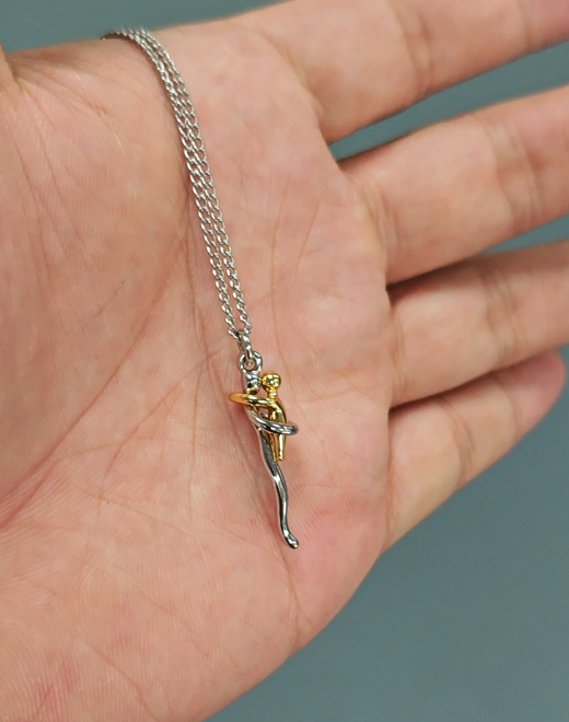Le collier posé dans le creux d'une main, qui permet d'apprécier la petite taille du pendentif et la finesse de la chaîne. 7