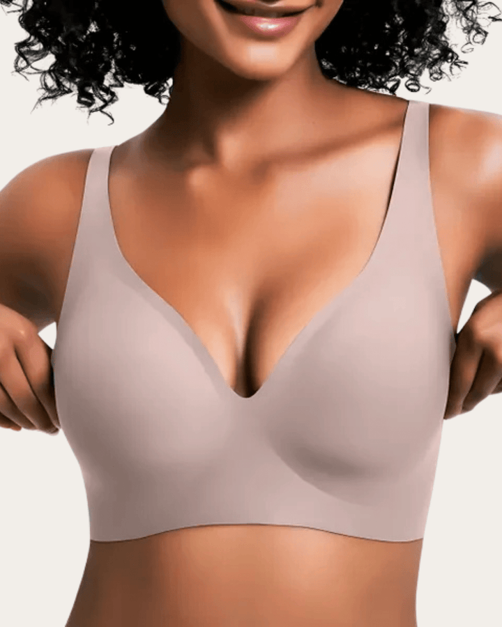 Soutien-gorge sans couture uni rose poudré grisé, col en V, porté de face par une femme aux cheveux bouclés. 10