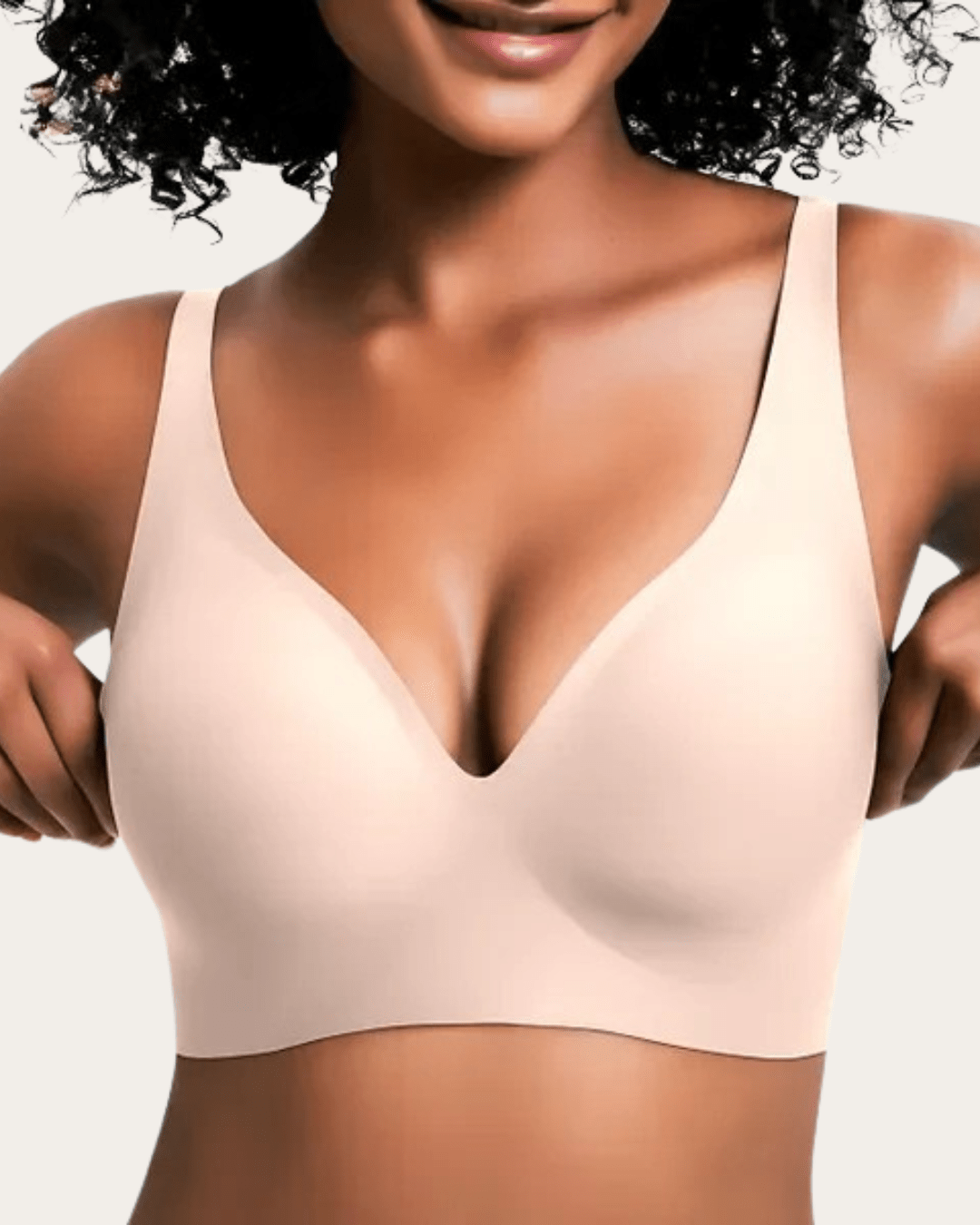 Soutien-gorge sans couture uni de teinte chair claire, col en V, porté de face par une femme aux cheveux bouclés. 6