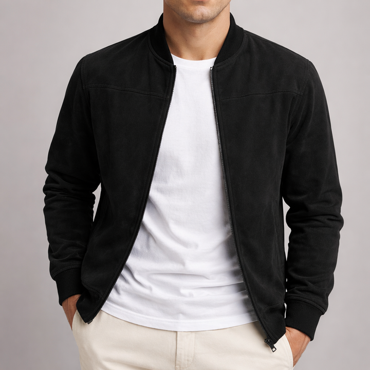 Version noire de la veste portée ouverte sur un t-shirt blanc, les mains dans les poches d'un pantalon beige. 5