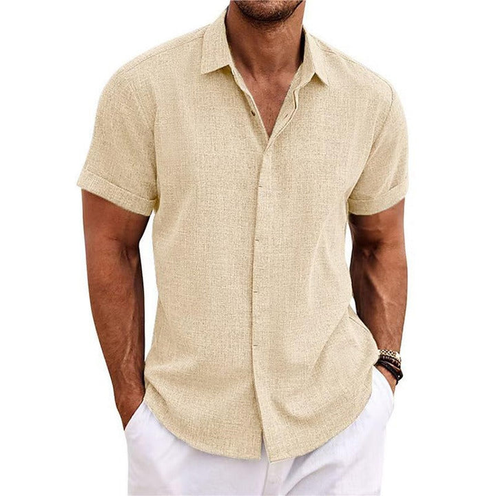 Chemise beige clair à manches courtes retroussées, portée avec un pantalon blanc, mains dans les poches, vue de face. 11