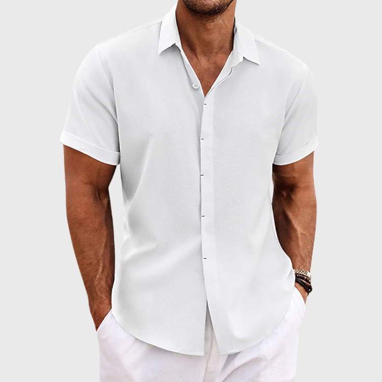 Chemise blanche à manches courtes et col boutonné, portée avec un pantalon blanc, vue de face sur fond gris clair. 3