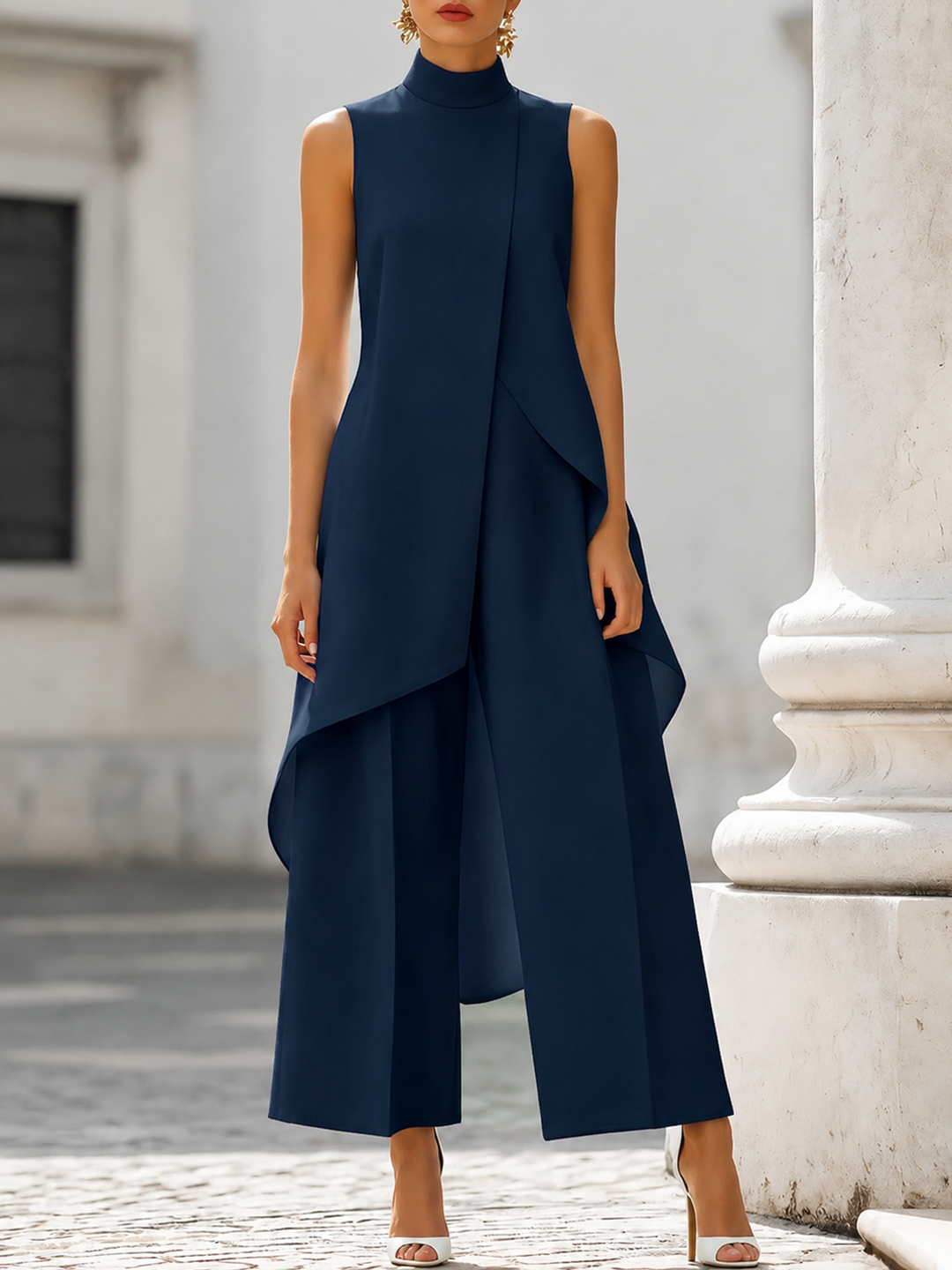 Version bleu marine foncé portée de face, col montant, haut asymétrique sans manches et pantalon large aux jambes droites. 6