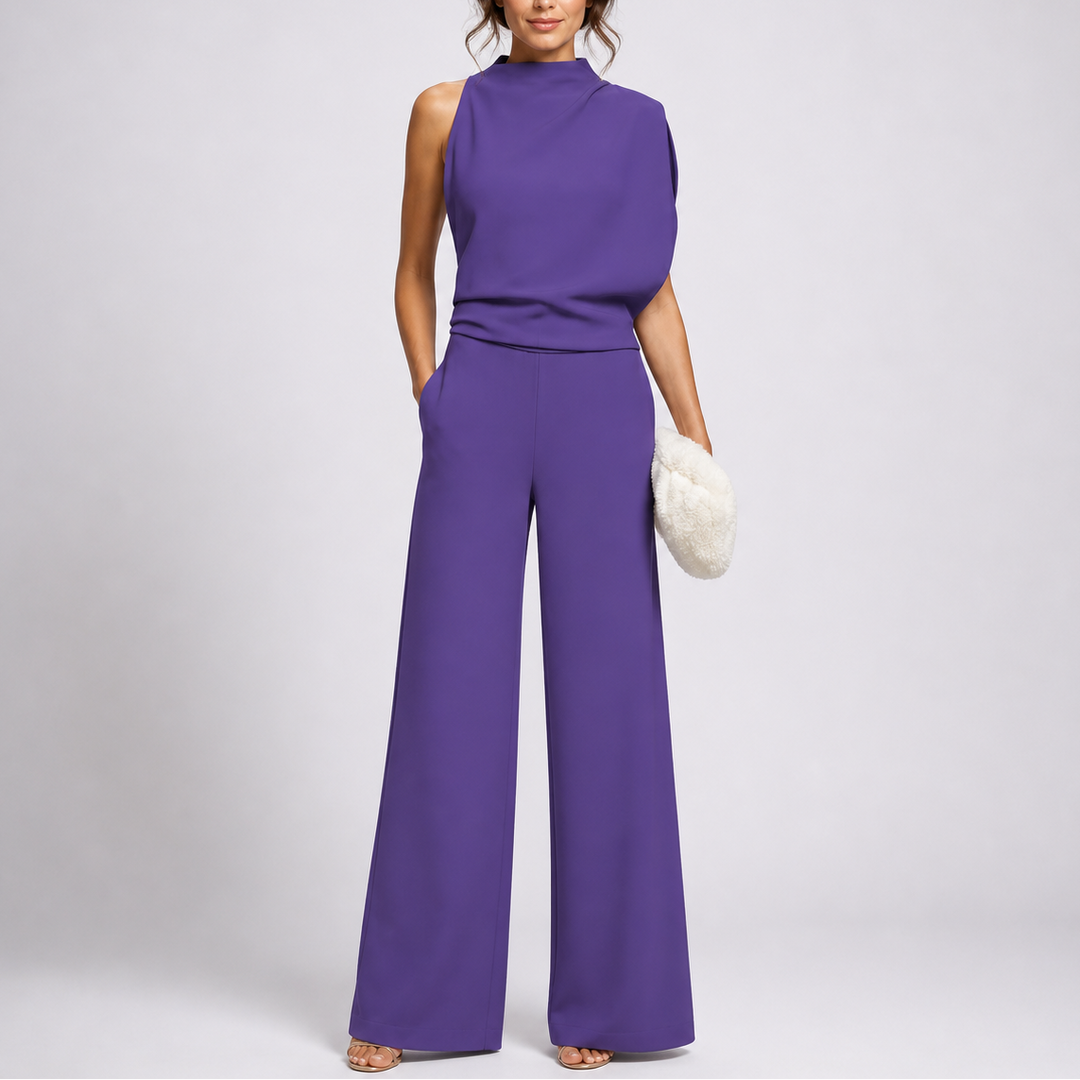 Femme portant la combinaison violette sans manches au drapé asymétrique sur l'épaule, sandales dorées et pochette blanche 3