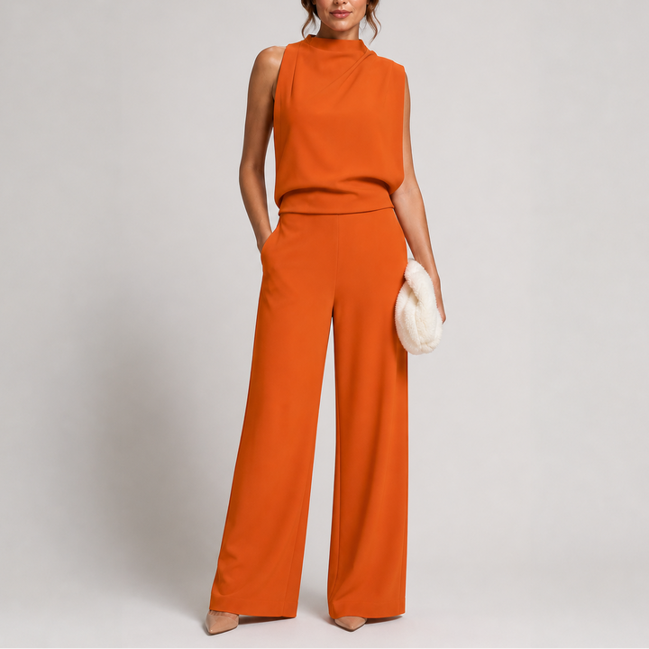 Femme portant la combinaison orange rouille sans manches, jambes larges, escarpins nude et pochette blanche 5
