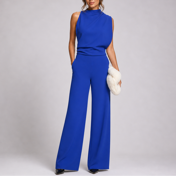 Femme portant la combinaison bleu roi sans manches au haut drapé, escarpins noirs et pochette blanche 6