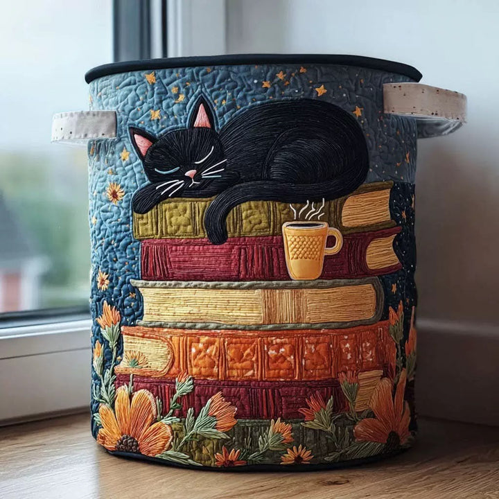 Panier rond matelassé bleu avec un chat noir endormi sur une pile de livres colorés, posé sur un rebord de fenêtre. 1