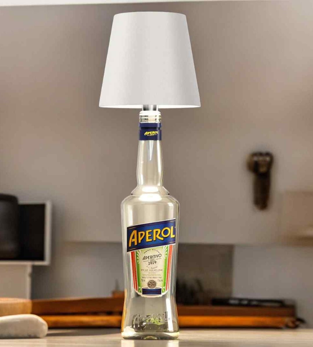 Abat-jour blanc posé sur une bouteille transparente d'apéritif, sur un plan de travail de cuisine lumineux. 3