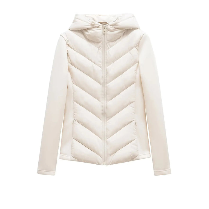Veste écru à capuche présentée à plat de face, zip fermé, matelassage en chevrons et poches zippées discrètes. 10