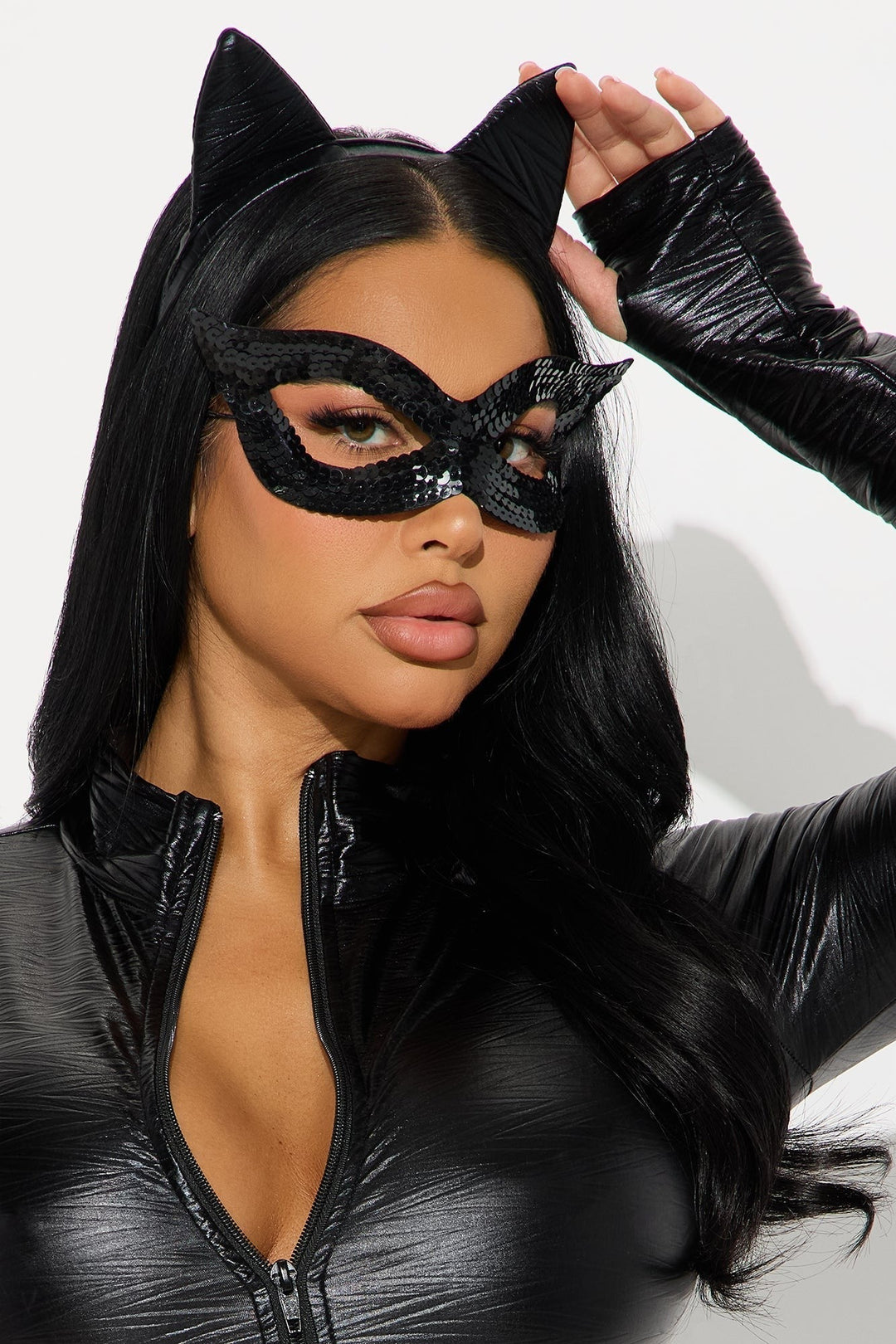 Gros plan sur le masque noir à sequins et le serre-tête à oreilles, une main relevant l'oreille 3