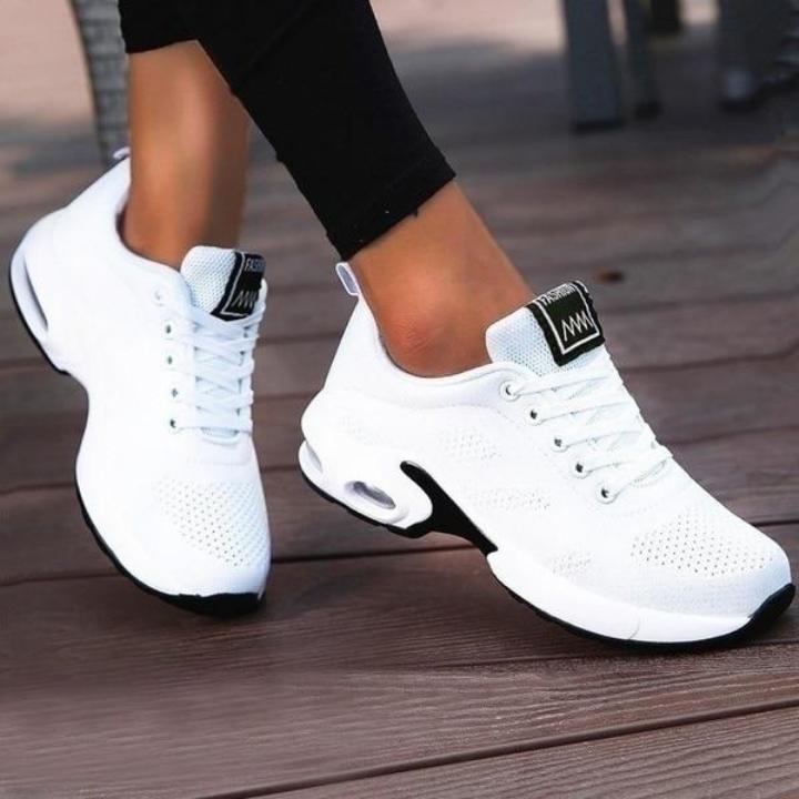 Baskets blanches en maille perforée à semelle noire et blanche avec bulle d'air, portées avec un legging noir. 3