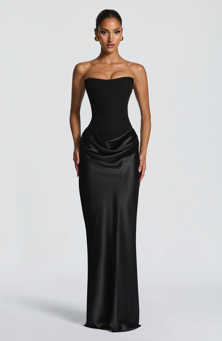 Robe noire portée par un mannequin, vue de face sur fond gris, bustier et jupe drapée 23