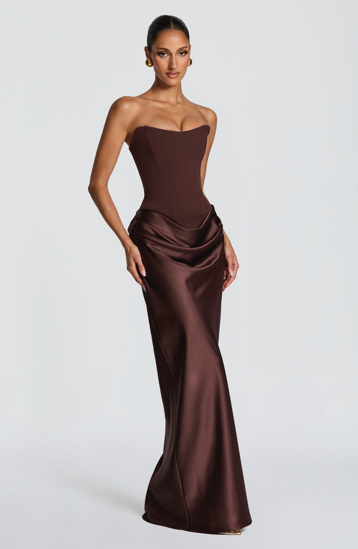 Robe marron portée de trois quarts, jupe satinée drapée sur la hanche, fond gris 3