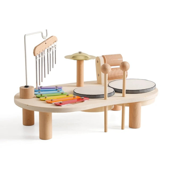 Table musicale en bois sur fond blanc avec xylophone arc-en-ciel, carillons, cymbale, deux tambours et baguettes 1