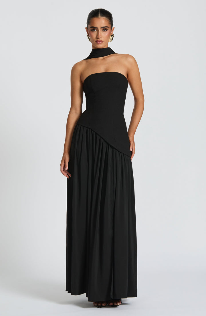 Robe noire portée de face, bustier asymétrique, écharpe autour du cou et jupe plissée 8
