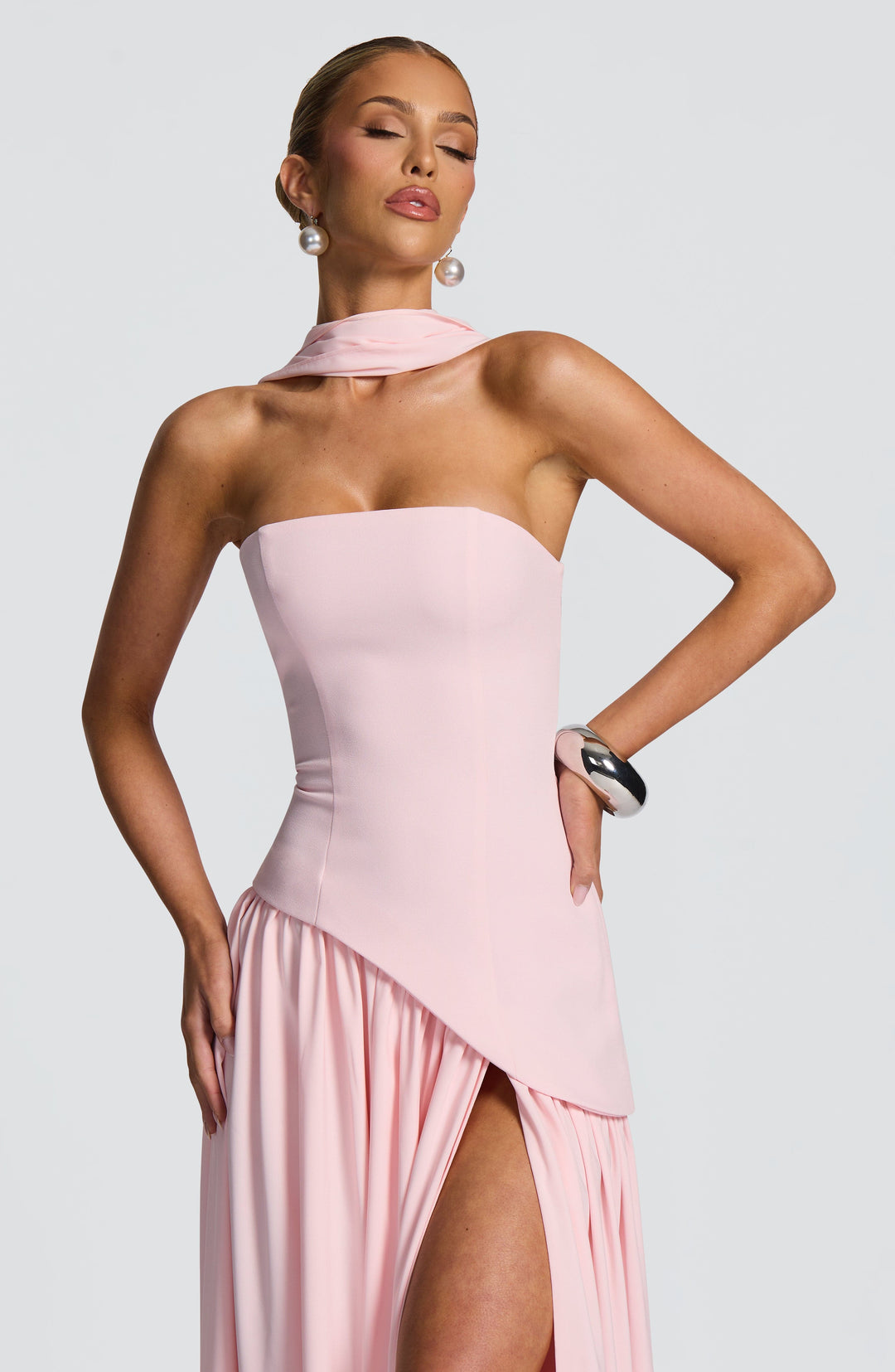 Gros plan sur le buste de la robe rose pâle, écharpe nouée au cou et fente de la jupe 24