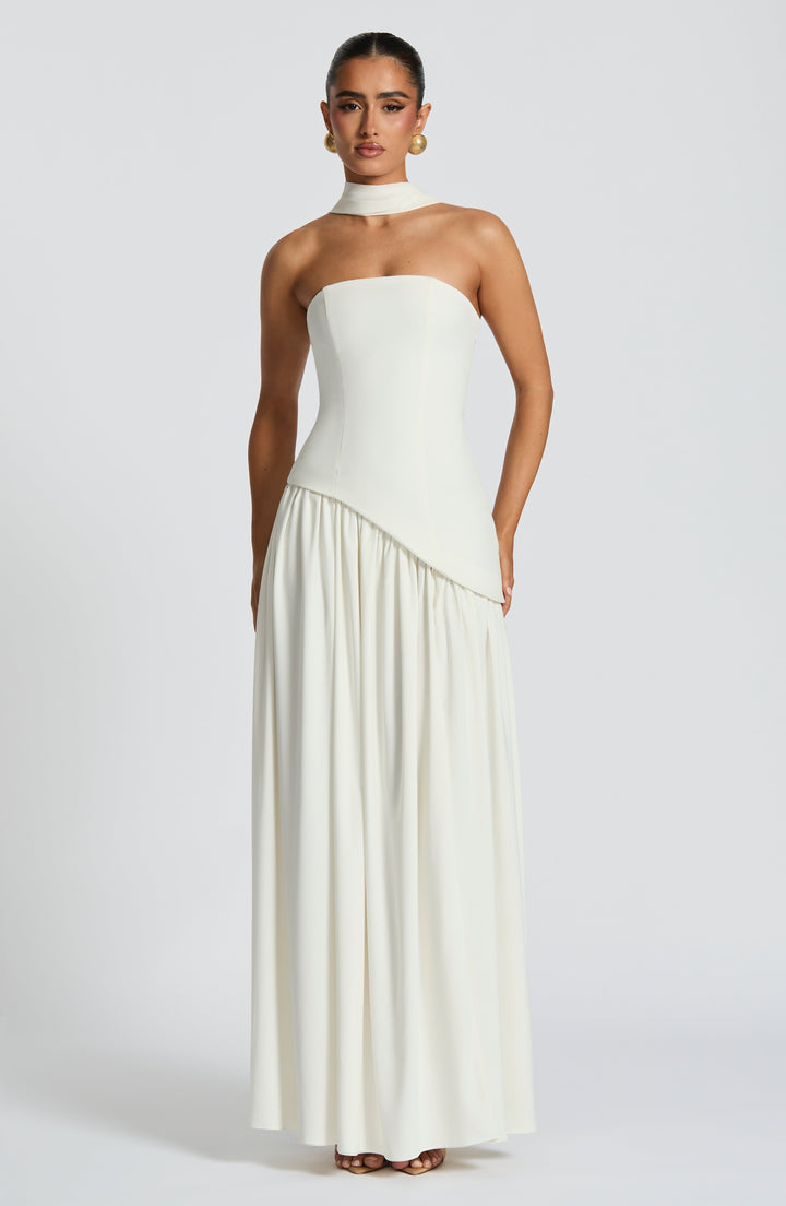 Robe blanc cassé portée de face, bustier asymétrique, col drapé et longue jupe froncée 34