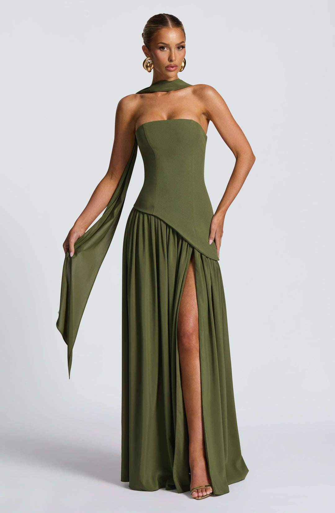 Robe vert olive portée de face, écharpe drapée au cou, jupe fendue et main sur la hanche 30