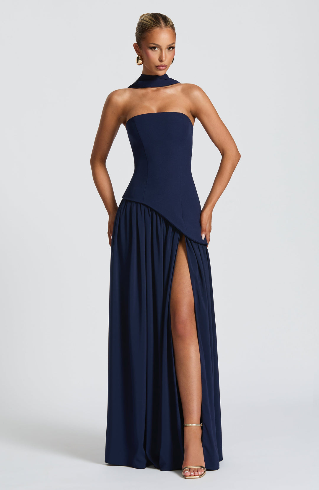 Robe bleu marine de face, mains sur les hanches, bustier asymétrique et fente haute 11