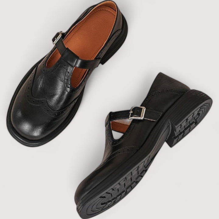Paire de babies noires vue de dessus, l'une montrant l'intérieur en cuir fauve, l'autre retournée sur sa semelle crantée. 5