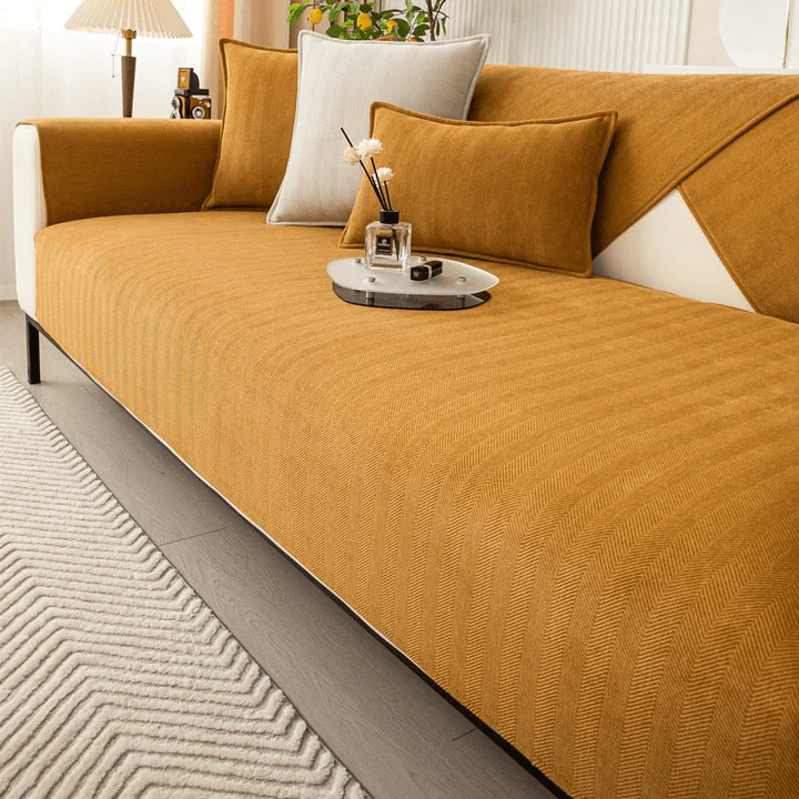 Housse de canapé moutarde à chevrons sur l'assise, avec coussins assortis et crème et plateau décoratif posé dessus. 6