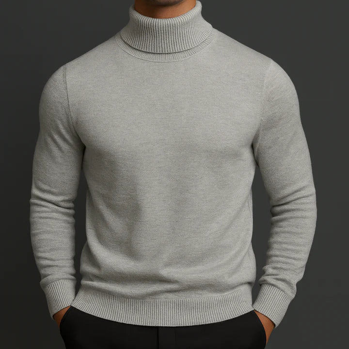 Homme portant le pull col roulé gris clair chiné, vu de face, mains dans les poches 2